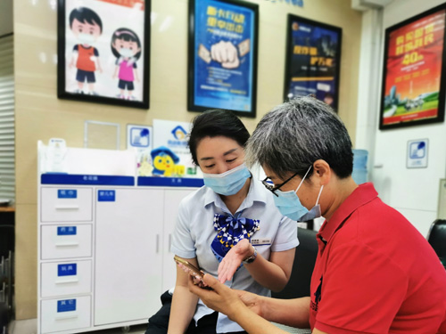 建行成都第六支行，大堂經(jīng)理為客戶介紹手機銀行&ldquo;大字&rdquo;模式